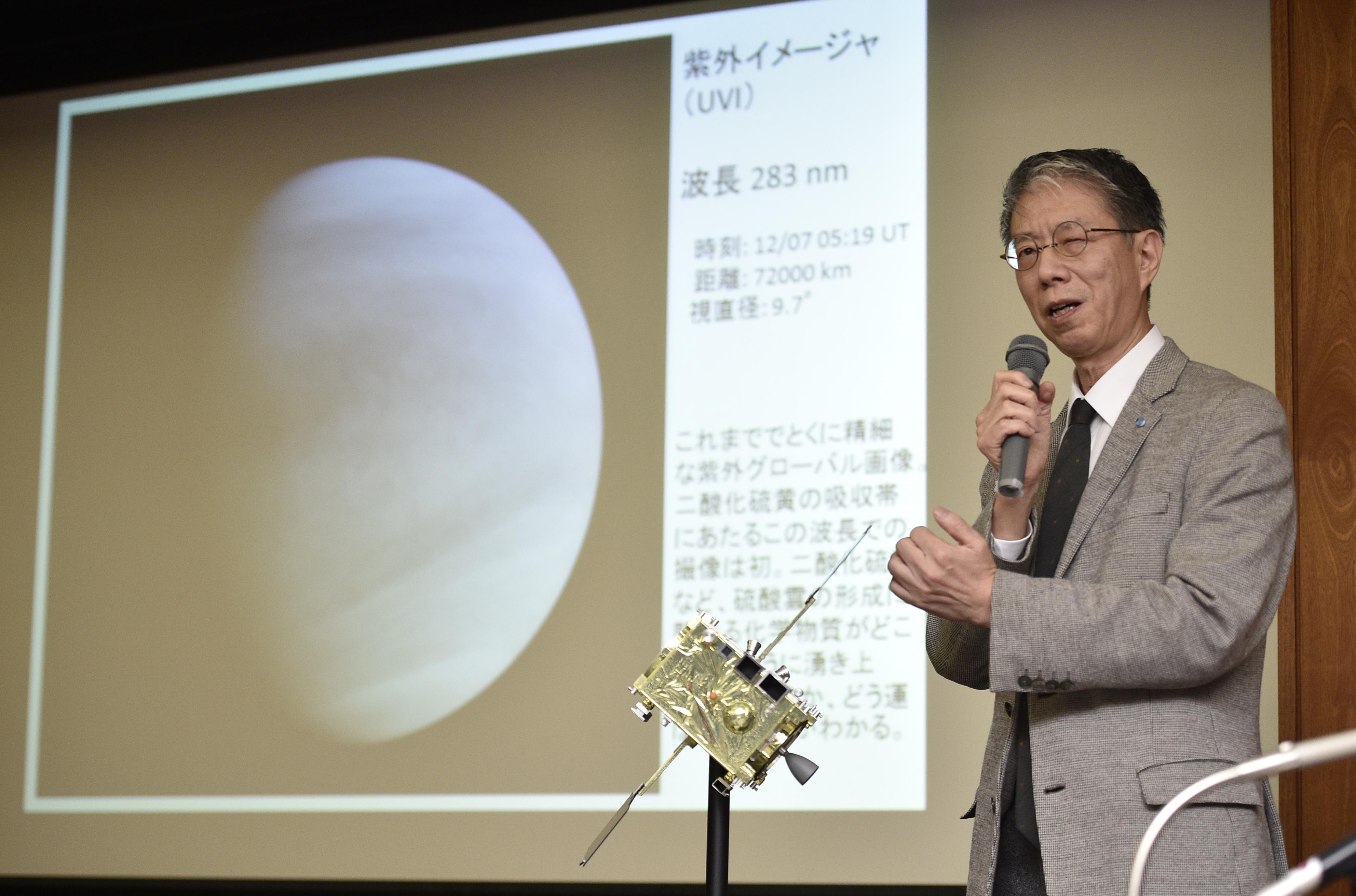 Masato Nakamura, a professor at the Japan Aerospace Exploration Agency (JAXA), shows pictures taken by the Akatsuki probe on December 9, 2015.