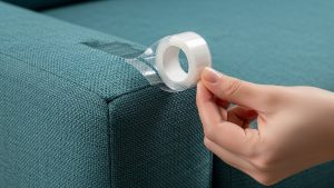 Using double-sided tape is a temporary deterrent while learning how to stop cats from scratching furniture.